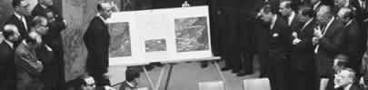 from 1963 a photo of men in suits looking at  recon. photos of secret Cuba missile program